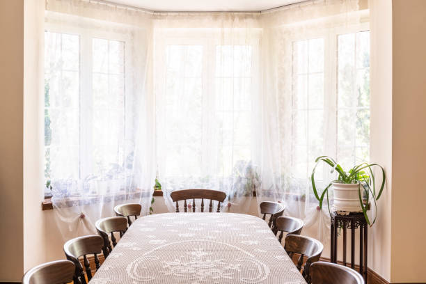 Old style dining room interior with a big window decorated with curtains, table with chairs and plant. Real photo Old style dining room interior with a big window decorated with curtains, table with chairs and plant. Real photo hampton virginia photos stock pictures, royalty-free photos & images