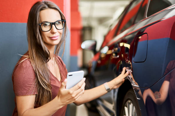 Portrait of young woman with scratched car at underground parking lot Portrait of young woman with scratched car at underground parking lot car insurance photos stock pictures, royalty-free photos & images