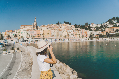 Young Caucasian woman taking photo of  view of Cassis town in French Riviera