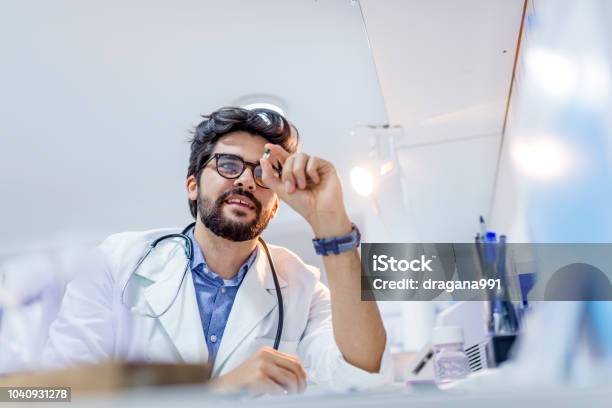 Young Attractive Male Scientist Holding A Pill Stock Photo - Download Image Now - Nutritional Supplement, Pharmaceutical Factory, Scientist