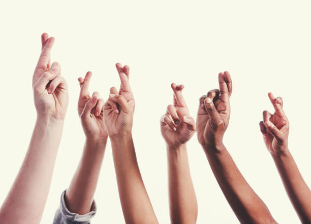 istock Large mixed group of hands raised, all with fingers crossed 1040932556