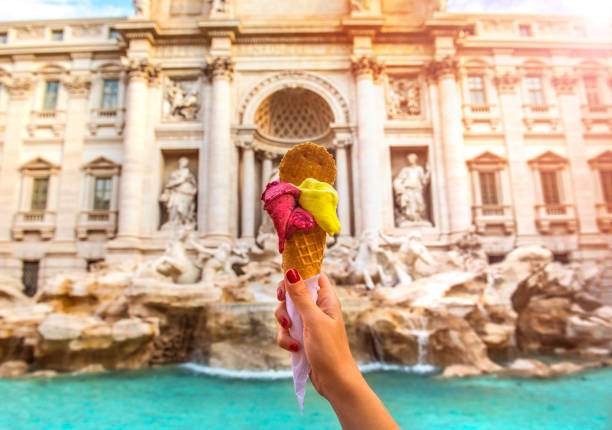 Famous Italian Gelato at Trevi Fountain Rome Hand holding colorful gelato in front of famous iconic Trevi Fountain at Rome, Italy. european culture photos stock pictures, royalty-free photos & images