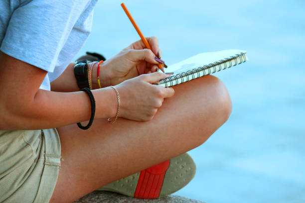 istock girl draws in a notebook sitting on the pavement 1040936308