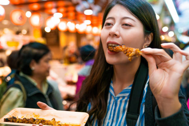 istock asian visitor eating grilled chicken. 1040936642