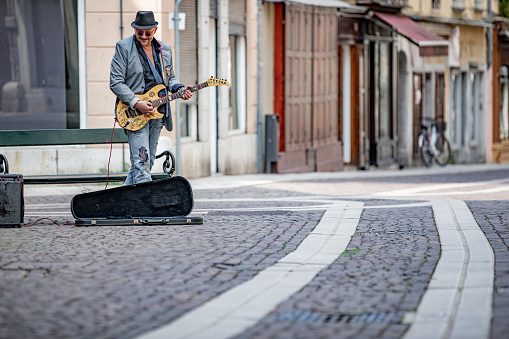 Senior Street Performer Playing Electric Guitar on Italian City Street.