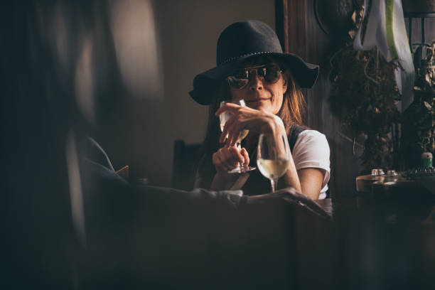 Mature Woman Sitting in a Bar and Drinking Wine.