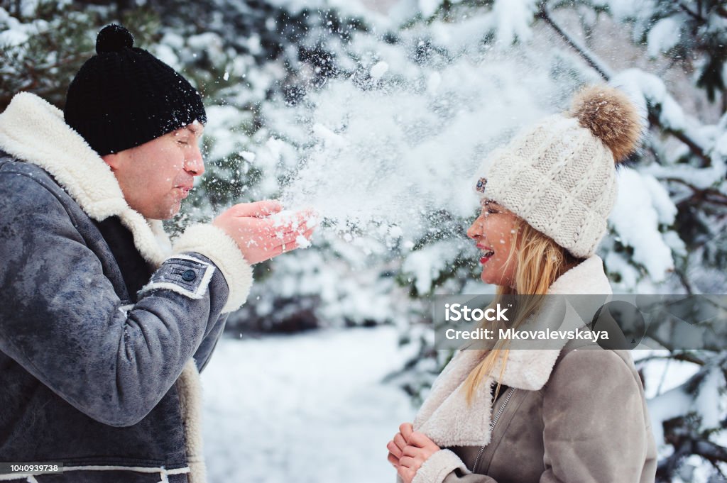 Foto de Retrato De Inverno De Casal Feliz Jogando Soprando A Neve E Passar Um Bom Dia Ao Ar Livre No Bosque Nevado Actividades Sazonais Nos Feriados e mais fotos de stock Foto de Retrato De Inverno De Casal Feliz Jogando Soprando A Neve E Passar Um Bom Dia Ao Ar Livre No Bosque Nevado Actividades Sazonais Nos Feriados e mais fotos de stock