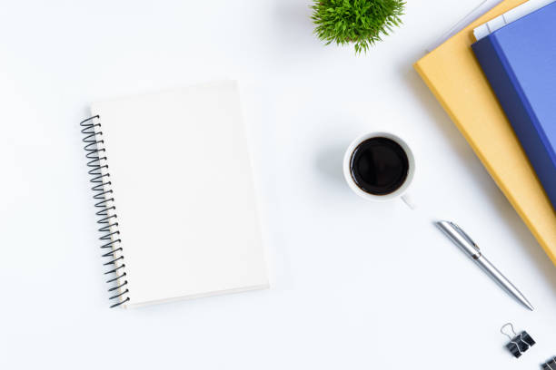 istock White office desk table and equipment for working with black coffee and white book in top view and flat ray concept. 1040941120