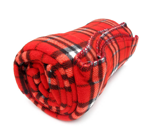 Rolled up red plaid blanket against white background