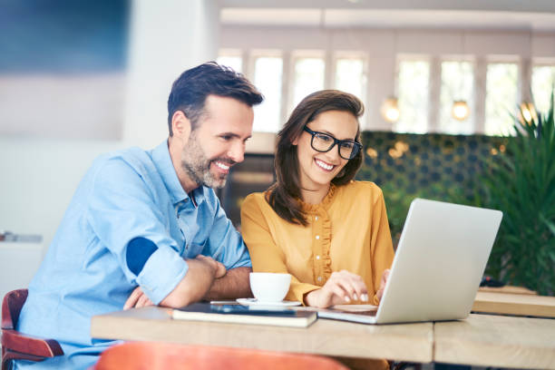 istock Joyful couple using laptop while having coffee in cafe together 1040944202