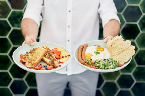 istock Man holding two plates with delicious breakfast. Chef presenting food in restaurant 1040949270