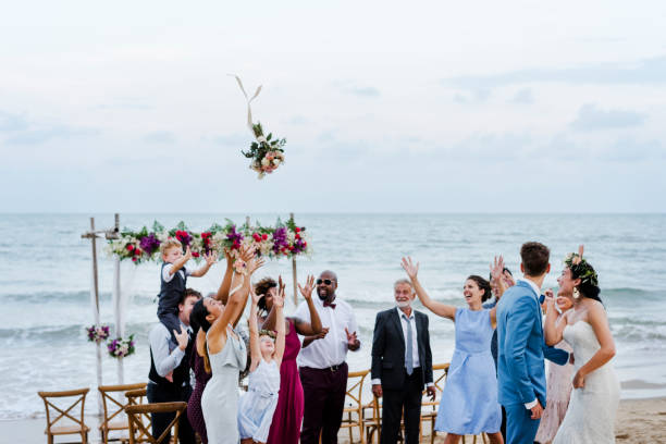 sposa che lancia il bouquet al matrimonio - wedding beach bride groom foto e immagini stock