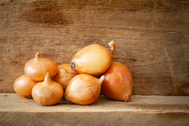 istock Golden Onions on a Wooden Plank 1040950036