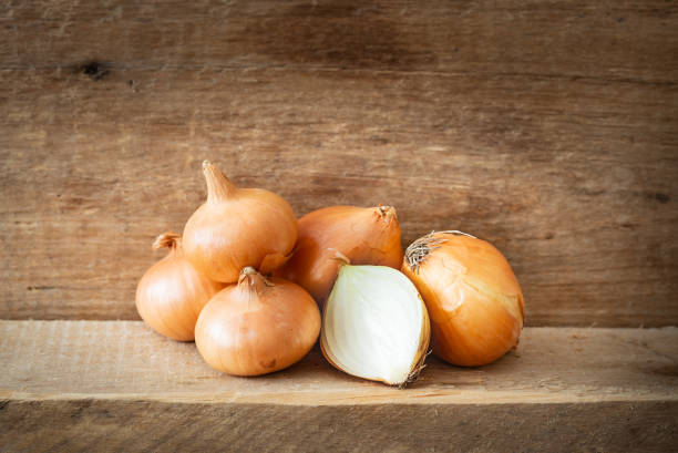 Golden Onions on a Wooden Plank stock photo