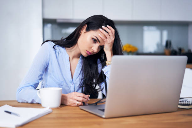 istock Tired woman working with laptop in home office 1040957522