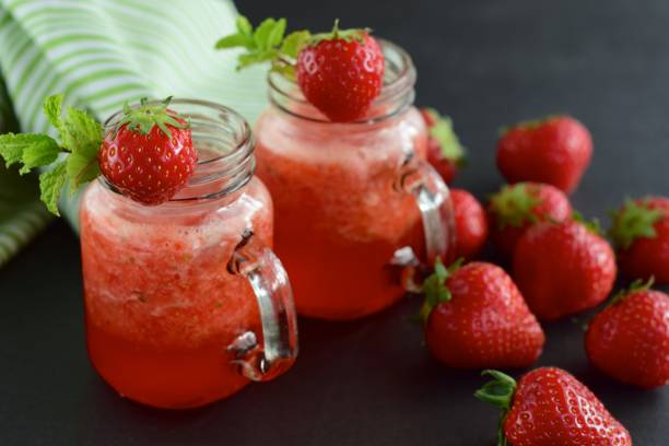 istock Fresh strawberry juice with mint leaf in a jar on black background 1040960196