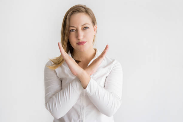 istock Serious beautiful woman showing crossed hands 1040960298