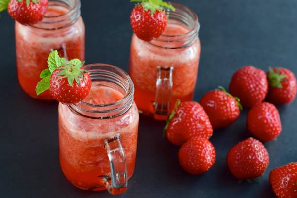 istock Fresh strawberry juice with mint leaf in a jar on black background 1040960304