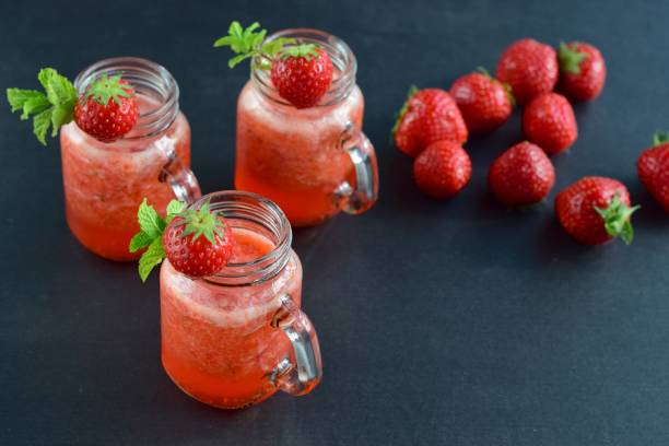 istock Fresh strawberry juice with mint leaf in a jar on black background 1040960372