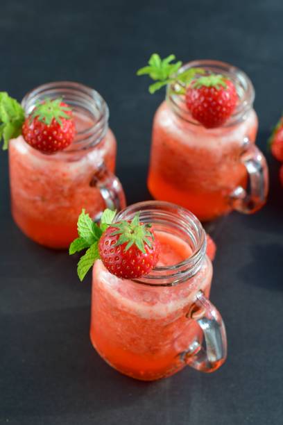 istock Fresh strawberry juice with mint leaf in a jar on black background 1040960396