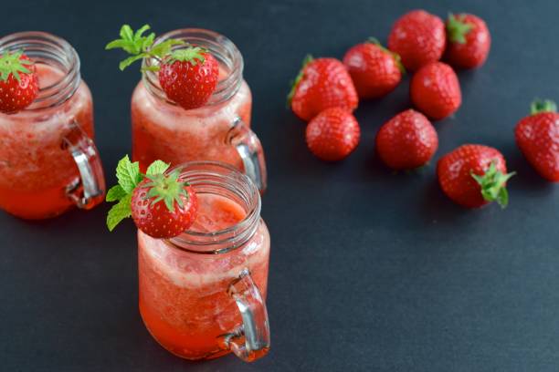 istock Fresh strawberry juice with mint leaf in a jar on black background 1040960762