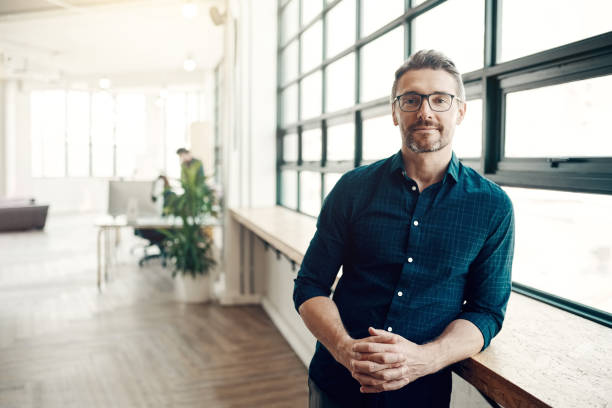 Stay hungry for success Portrait of a confident mature businessman working in a modern office looking at camera stock pictures, royalty-free photos & images