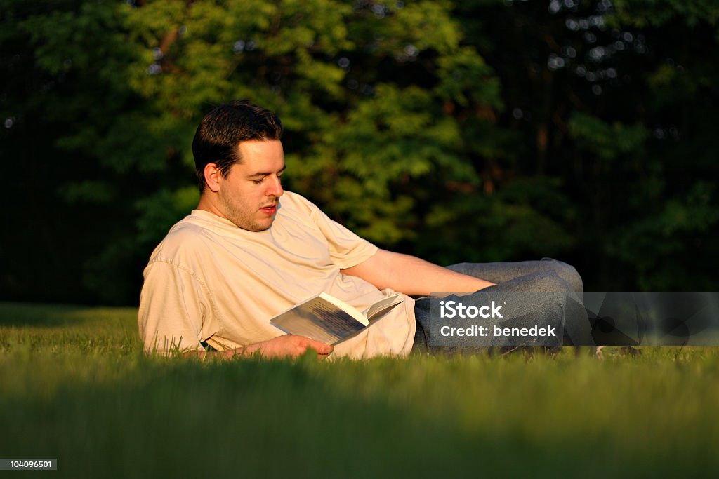 Jeune homme la lecture à l'extérieur - Photo de Activité de loisirs libre de droits