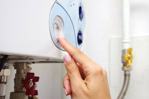 istock Female adjusting a central heating gas boiler at home. 1040967260