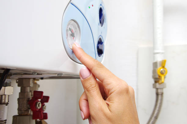 fêmea, ajustando uma caldeira de aquecimento central de gás em casa. - boiler gas boiler thermostat control panel - fotografias e filmes do acervo