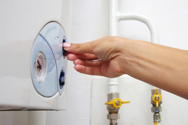 istock Female adjusting a central heating gas boiler at home. 1040967290