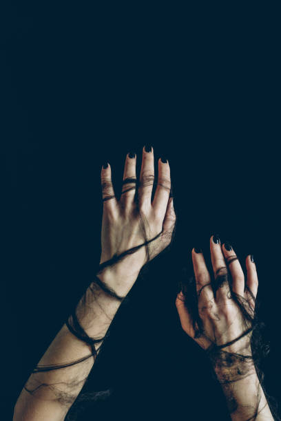 istock cropped view of female hands in black spider web isolated on black 1040971014