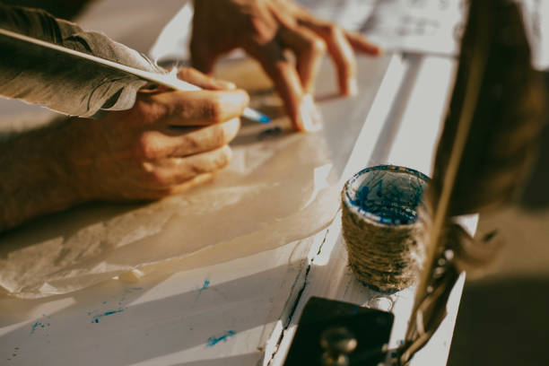 istock Human hands write a bird pen, ancient way of writing 1040975756