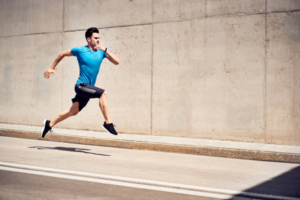 건강 및 피트 니스 개념입니다. 전속력으로 달리 고 점프 하는 남자 도시에서 운동 세션 동안 연습 - muscular build sprinting jogging athlete 뉴스 사진 이미지
