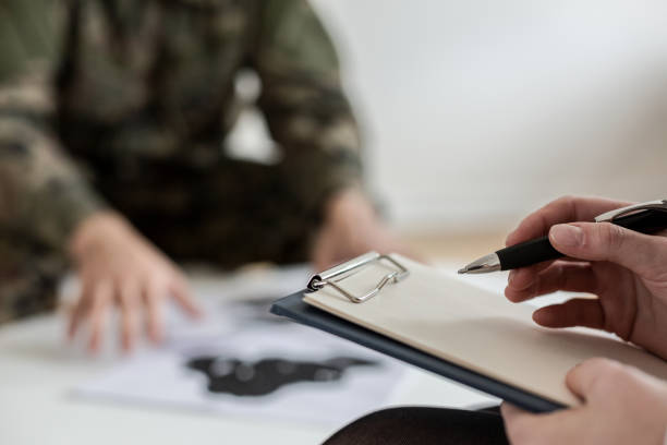 istock Close-up on psychotherapist taking notes while analysing behavior of soldier during meeting 1040976628