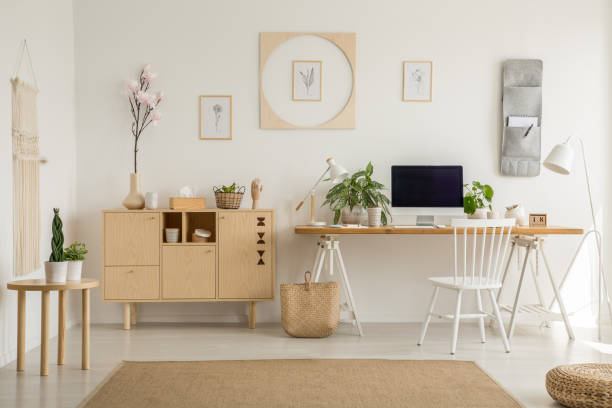 istock Wooden cupboard next to desk with desktop computer and plants in home office interior. Real photo 1040979146