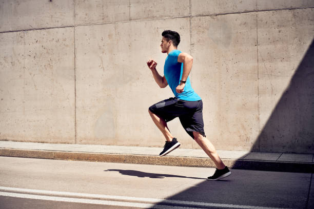 istock City workout concept. Athletic man doing running exercises on unused road 1040980094