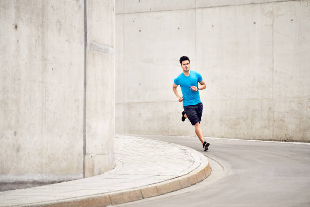istock Athletic man running on road in the city. Outdoors training concept 1040980606