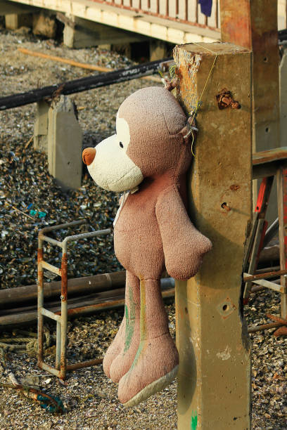 istock Old teddy bear is hung at the pole. 1040985796