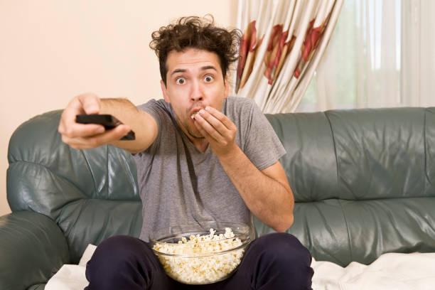 istock Lazy man with the remote on the couch 1040986142