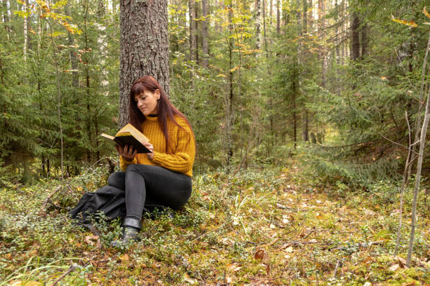istock Girl reading a book in the forest, toning 1040986966