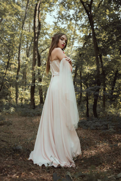 istock attractive mystic elf posing in elegant dress in forest 1040994854