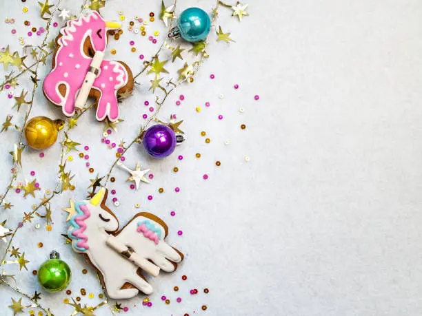 Photo of Christmas  multicolored balls and unicorn figurines on a white textural background