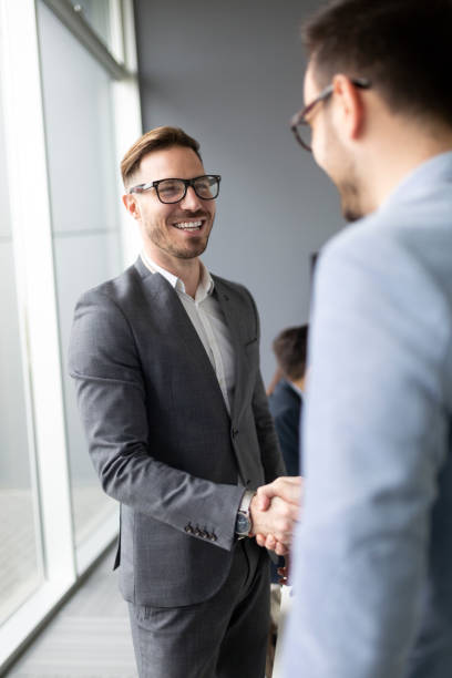 Business people shaking hands, finishing up meeting Business people shaking hands, finishing up successful meeting dealing cards stock pictures, royalty-free photos & images