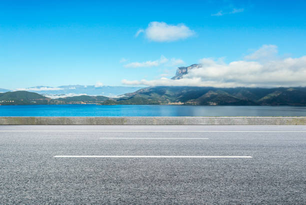 istock Bay side clean asphalt highway and afar island and boundless ocean, in sunny summer 1040998764