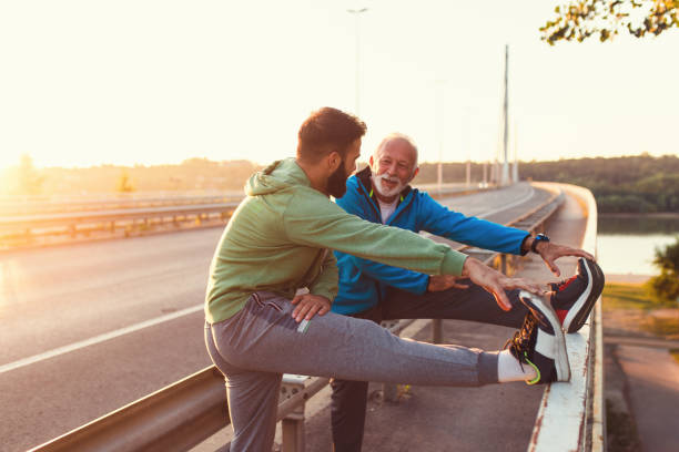 Father and son Happy father and son exercising together outdoors on big modern bridge. warm up exercise stock pictures, royalty-free photos & images