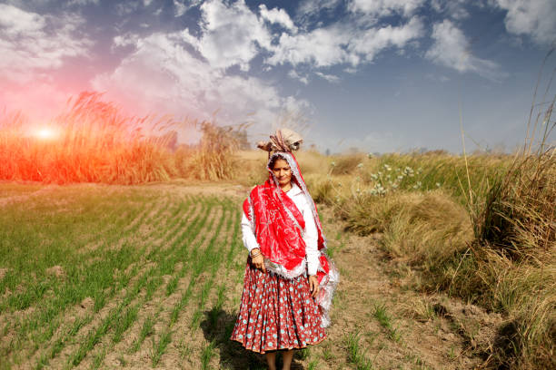Female farmer standing portrait near wheat crop field during springtime.