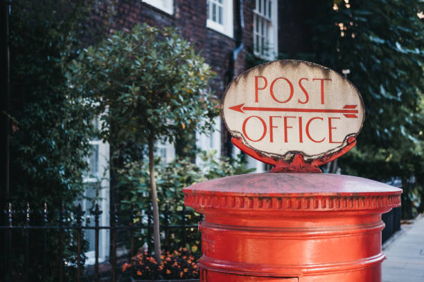 istock Red post box with a Post Office directional  sign in London, UK. 1041014304