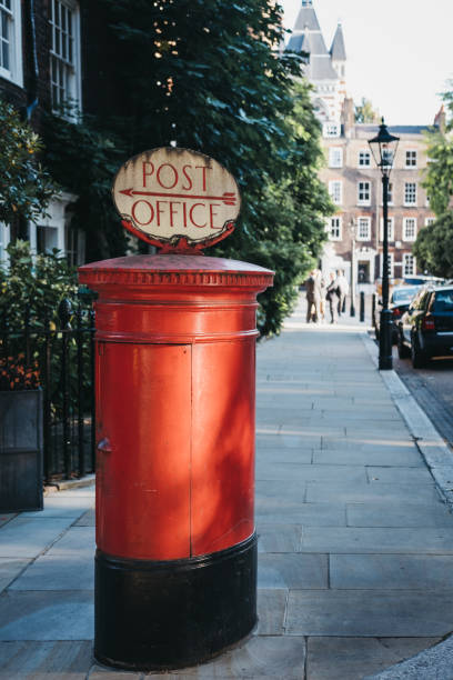 istock Red post box with a Post Office directional  sign in London, UK. 1041014316