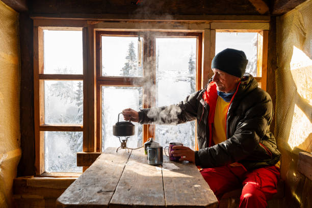 adventurer is drinking coffee and dreaming - home interior cabin shack european alps imagens e fotografias de stock