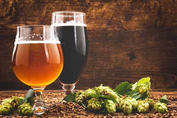 beer surrounded by hops on wooden background Craft beer backgrounds. Top view craft beer stock pictures, royalty-free photos & images